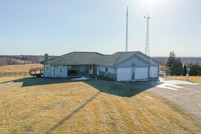 ranch-style home featuring a front lawn, an attached garage, fence, and driveway