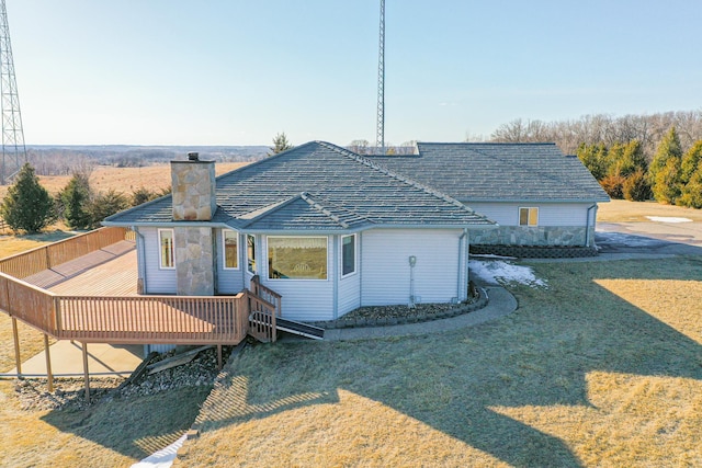 rear view of property with a deck and a chimney