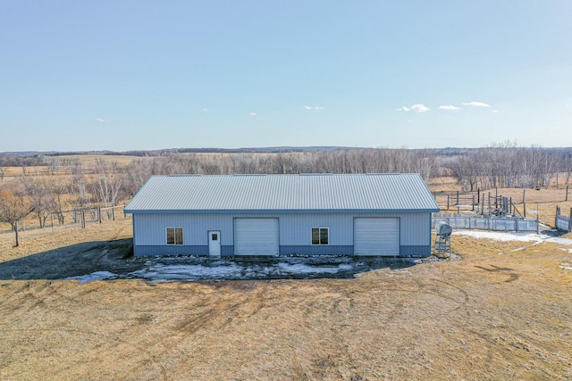 view of outbuilding with an outdoor structure, a rural view, and a garage