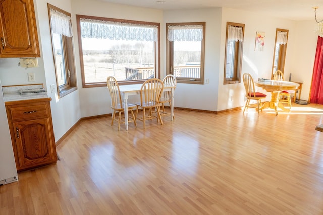 dining room with baseboards, light wood-type flooring, and a chandelier