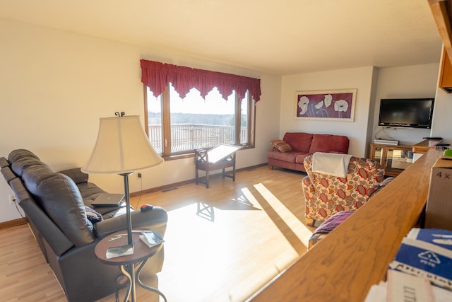 living area with light wood-type flooring and baseboards