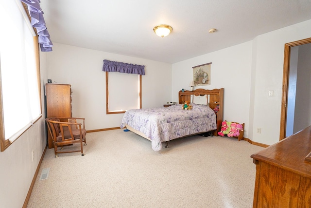 bedroom featuring visible vents, baseboards, and carpet