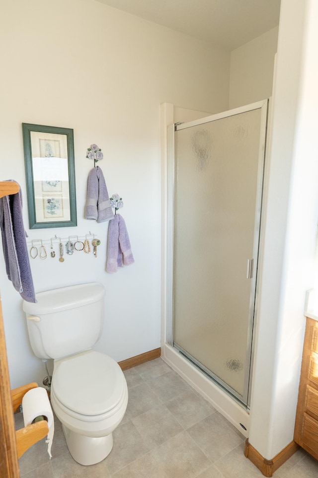 full bathroom featuring toilet, baseboards, and a stall shower