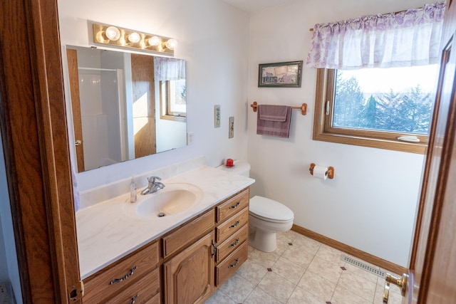 bathroom with tile patterned flooring, walk in shower, baseboards, toilet, and vanity