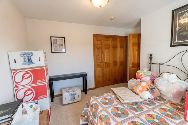 bedroom featuring a closet, baseboards, and carpet