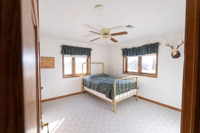 bedroom with a ceiling fan, baseboards, and visible vents