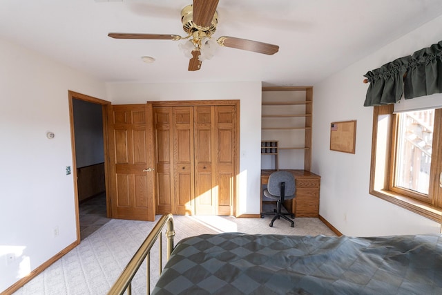 bedroom featuring a closet, baseboards, light carpet, and ceiling fan