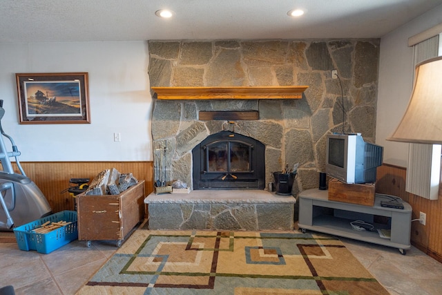 living room featuring wooden walls, recessed lighting, a fireplace, and a wainscoted wall