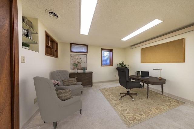 office space with baseboards, light colored carpet, visible vents, and a textured ceiling