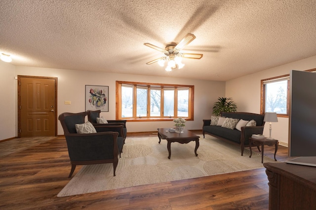 living area featuring a textured ceiling, a ceiling fan, and wood finished floors