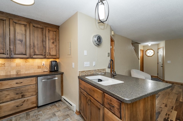 kitchen featuring stainless steel dishwasher, dark countertops, and a sink