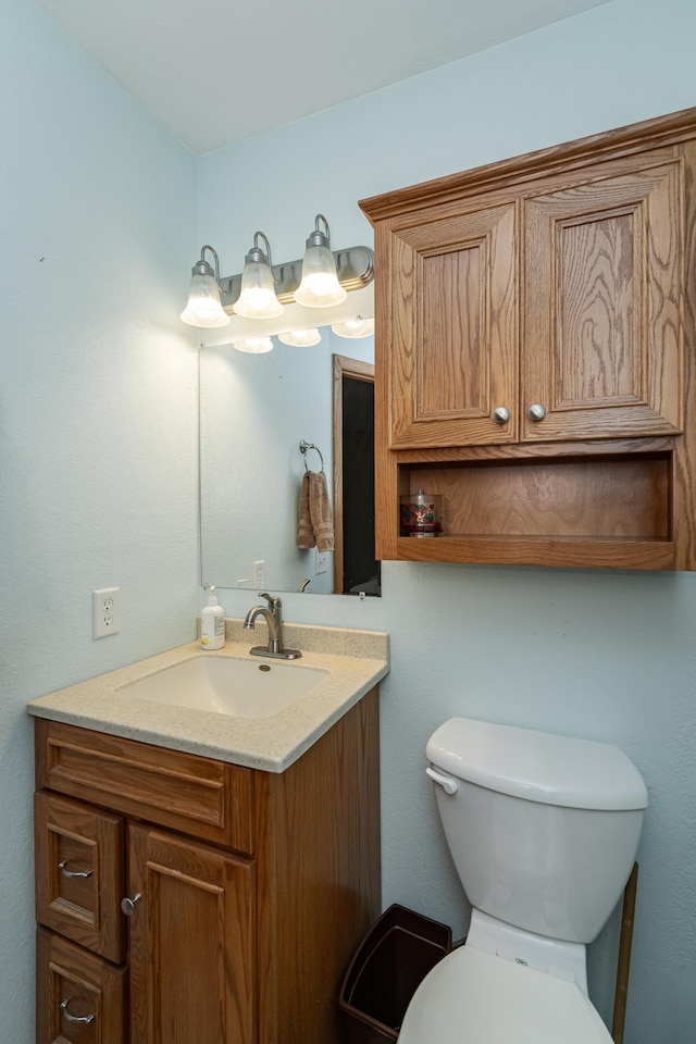 half bath featuring toilet and vanity