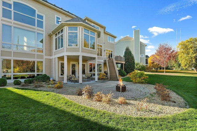 back of house with a lawn, an outdoor fire pit, stairs, and a patio area