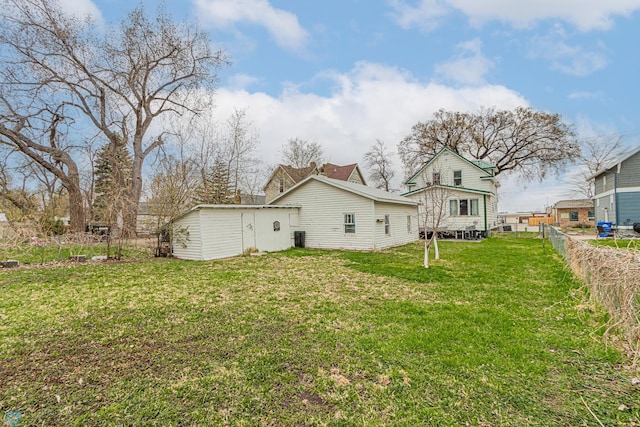 back of house featuring a lawn and fence