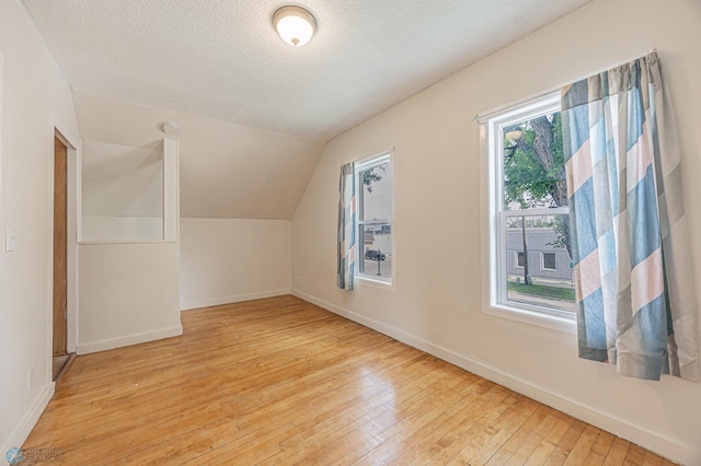 1524 1st Ave S, Fargo, ND 58103 - additional living space featuring hardwood / wood-style flooring, vaulted ceiling, baseboards, and a textured ceiling