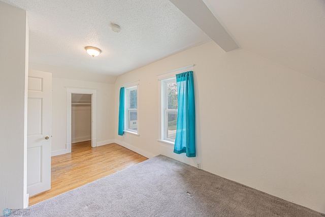 1524 1st Ave S, Fargo, ND 58103 - unfurnished bedroom with light wood-type flooring, light carpet, a closet, a textured ceiling, and beamed ceiling