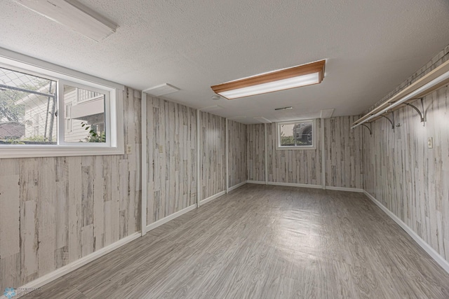 1524 1st Ave S, Fargo, ND 58103 - below grade area with wood finished floors, wooden walls, a textured ceiling, and baseboards