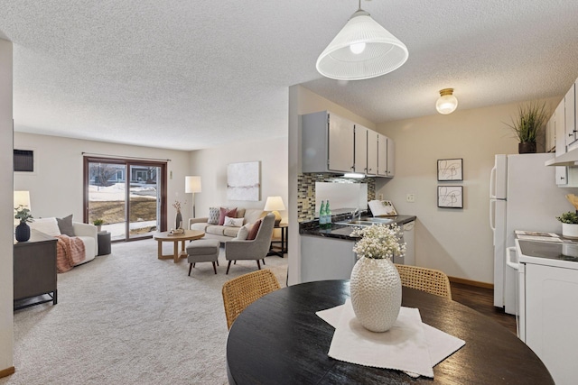 carpeted dining space featuring a textured ceiling