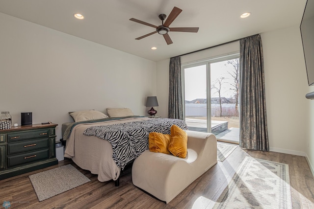 bedroom with access to outside, recessed lighting, wood finished floors, and baseboards