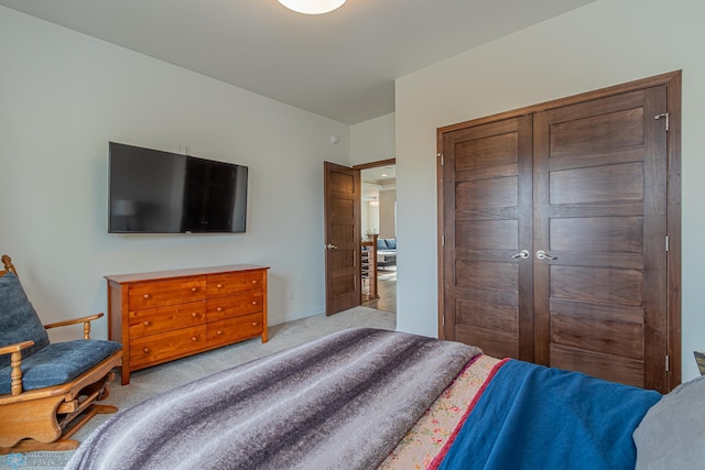 bedroom featuring light carpet and a closet