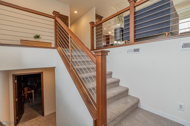 stairs with baseboards, visible vents, and carpet floors