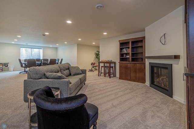 carpeted living room with a glass covered fireplace, recessed lighting, and baseboards