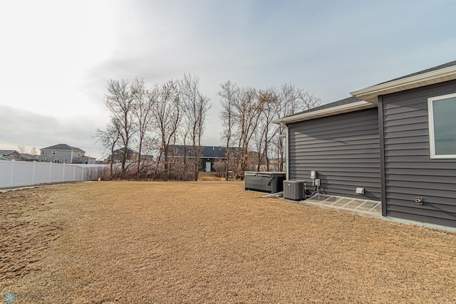 view of yard with central air condition unit and fence