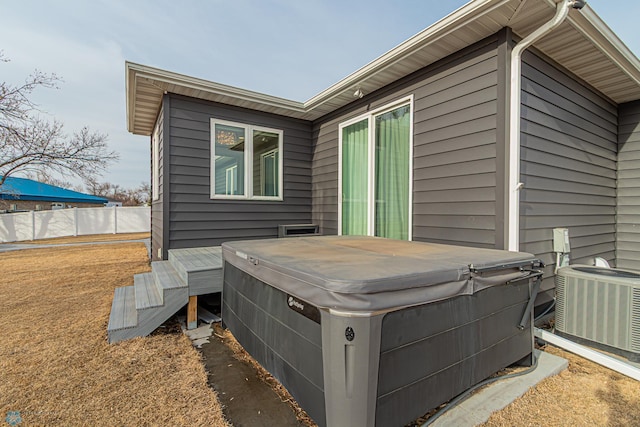 exterior space featuring fence, central AC, and a hot tub