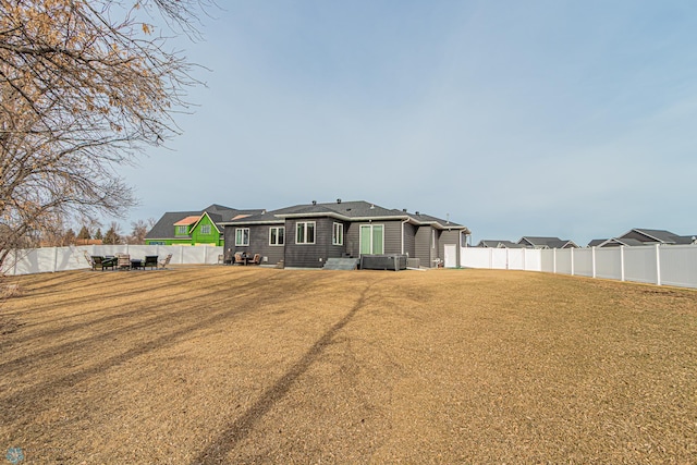 rear view of house featuring a lawn, central AC, and a fenced backyard