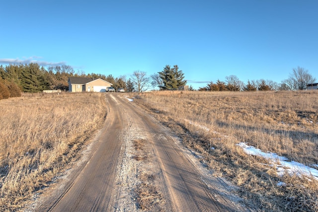 view of street featuring a rural view and dirt driveway