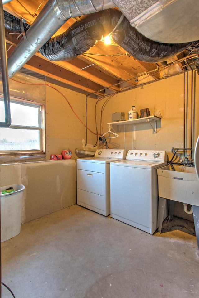 washroom with laundry area, separate washer and dryer, and a sink