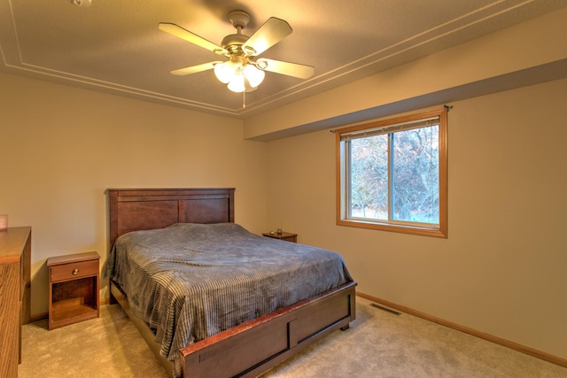 carpeted bedroom with visible vents, a ceiling fan, and baseboards