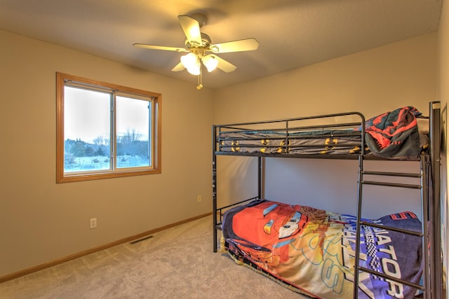 bedroom with baseboards, carpet floors, visible vents, and a ceiling fan