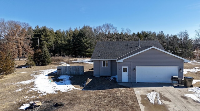 view of side of property featuring an attached garage and concrete driveway