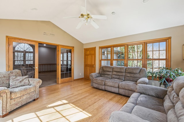 living room featuring french doors, light wood-style flooring, a ceiling fan, and vaulted ceiling