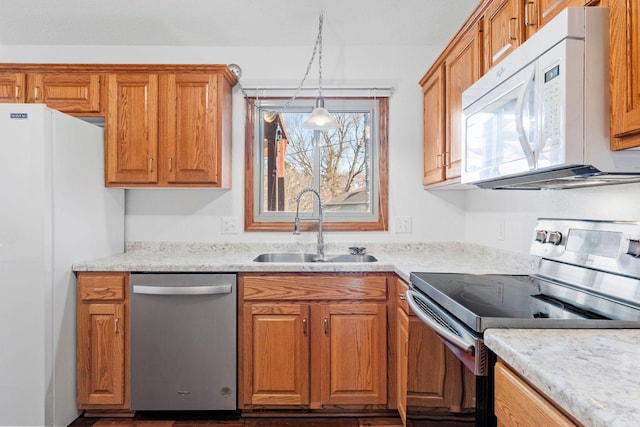 kitchen featuring a sink, brown cabinets, appliances with stainless steel finishes, and light countertops