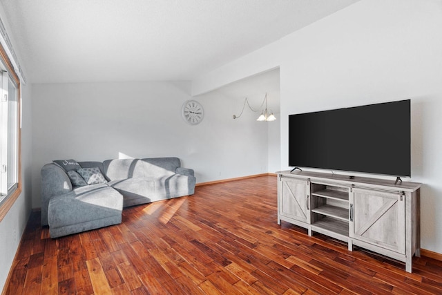 living area with vaulted ceiling, wood finished floors, and baseboards