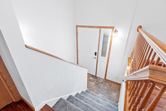 stairway with stone finish floor and baseboards