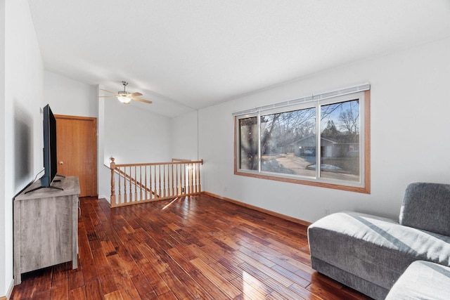 sitting room with baseboards, lofted ceiling, ceiling fan, hardwood / wood-style flooring, and an upstairs landing