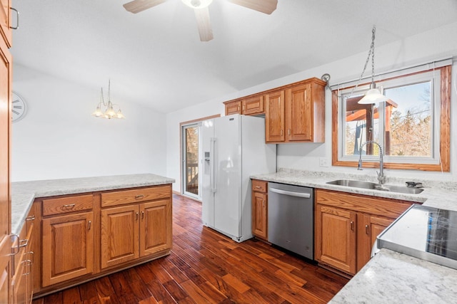 kitchen with dishwasher, white refrigerator with ice dispenser, brown cabinetry, and a sink