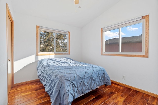 bedroom featuring hardwood / wood-style floors, lofted ceiling, baseboards, and ceiling fan