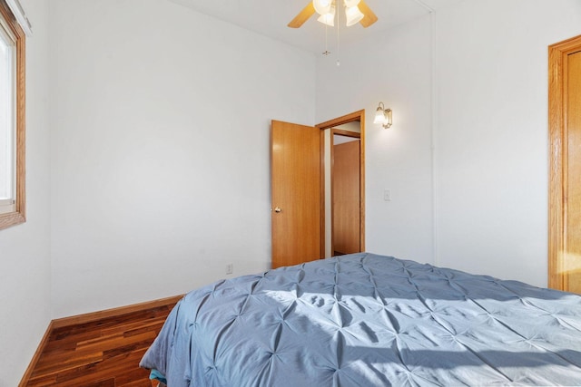 bedroom with wood finished floors, baseboards, and ceiling fan