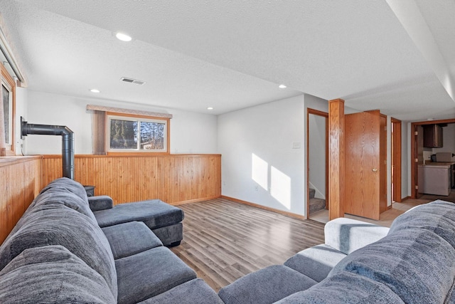 living room featuring recessed lighting, wood finished floors, visible vents, and a textured ceiling