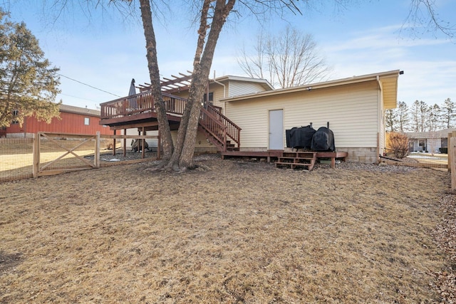 rear view of property featuring a wooden deck and fence