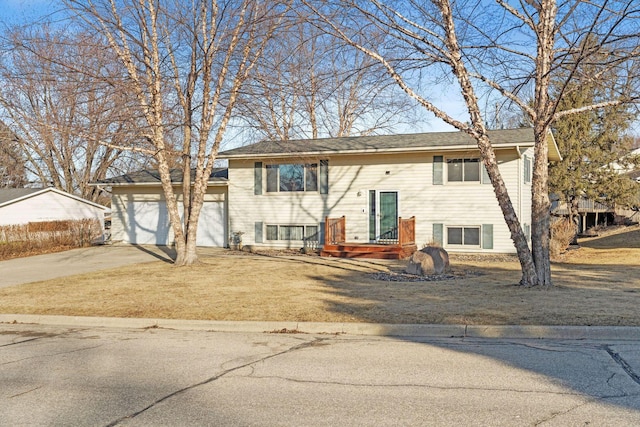 bi-level home featuring a garage, a front lawn, and driveway