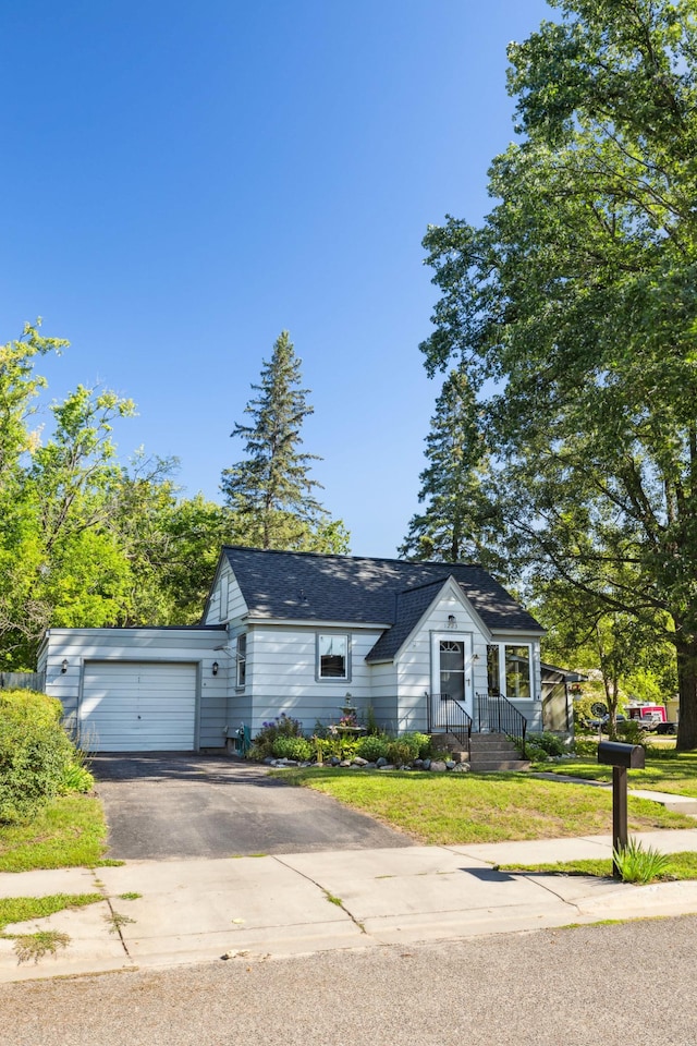 view of front facade featuring aphalt driveway, an attached garage, and a front lawn