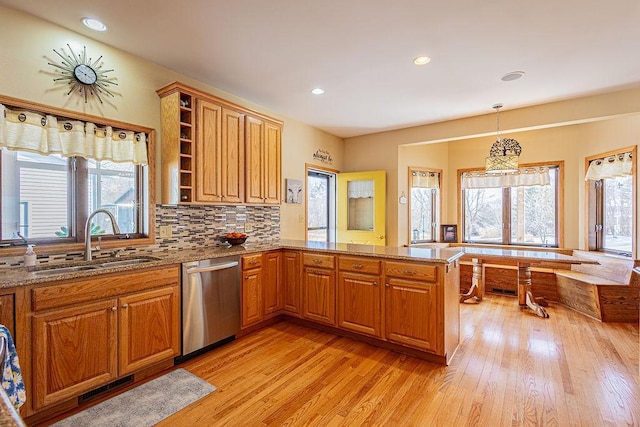 kitchen featuring visible vents, a sink, plenty of natural light, stainless steel dishwasher, and a peninsula