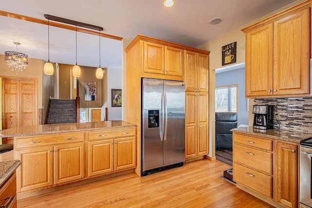 kitchen featuring tasteful backsplash, light stone countertops, decorative light fixtures, stainless steel fridge with ice dispenser, and light wood-style floors