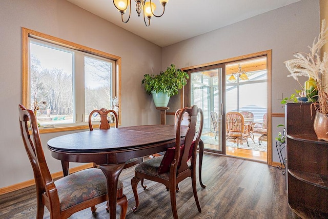 dining area featuring baseboards, wood finished floors, and a chandelier