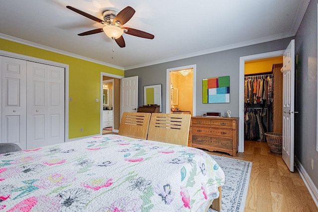 bedroom with a ceiling fan, light wood finished floors, a spacious closet, a closet, and crown molding